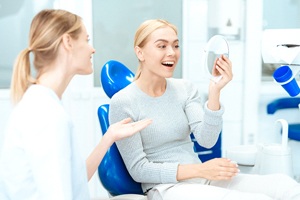 Happy patient admiring the results of her smile makeover