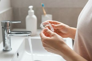 Person in bathroom, preparing to clean Invisalign aligner