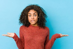 Woman shrugging while biting her lip