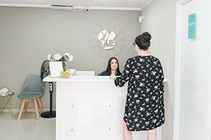 Patient and dental team member interacting at front desk
