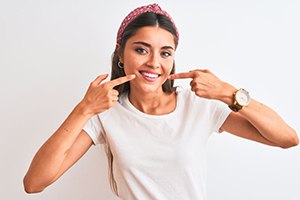 Young woman pointing at her healthy smile