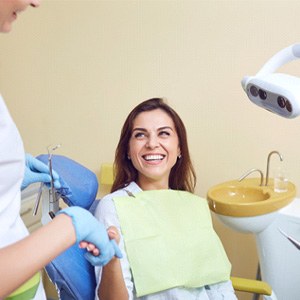 Happy patient shaking hands with her dentist