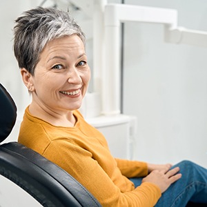 Happy middle-aged dental patient looking over her shoulder