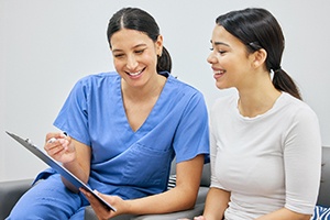 Patient and dental team member reviewing paperwork