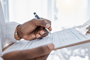 Doctor filling out form on clipboard