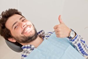 Male dental patient making thumbs-up gesture